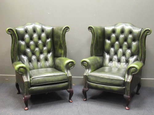Lot 424 - A pair of wing back armchairs with green...