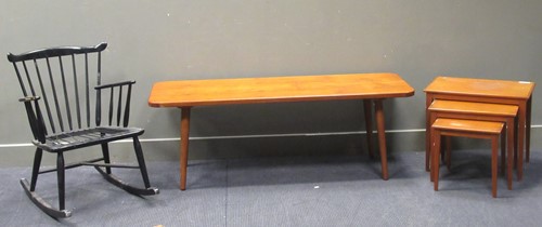 Lot 547 - A ebonised rocking chair, with a nest of three teak tables and a rectangular low table on tapered legs (3)
