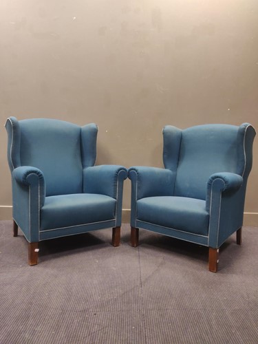 Lot 560 - A pair of blue upholstered wingback armchairs and two others (4)