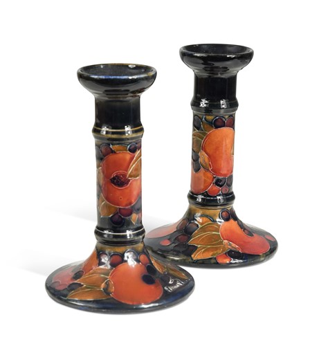 Lot 28 - A pair of Moorcroft Pomegranate pattern candlesticks