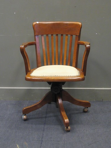 Lot 504 - An oak swivel desk armchair