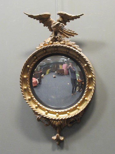 Lot 466 - A Regency style convex wall mirror surmounted...