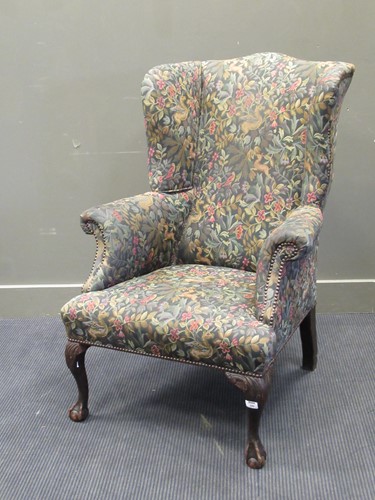 Lot 440 - A wingback armchair upholstered in William...