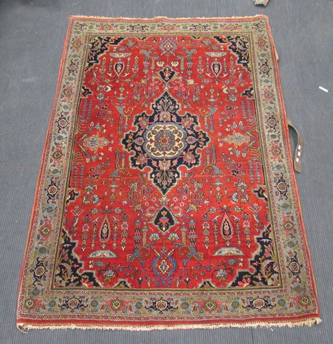Lot 520 - A Persian red ground rug with central...
