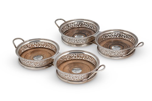 Lot 513 - A set of four George III silver bottle coasters