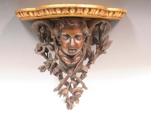 Lot 99 - A Black Forest carved wood winged putto wall...
