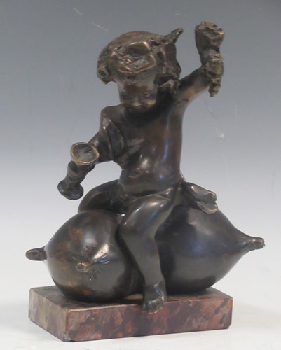 Lot 159 - A bronze model of a Bacchanalian putto upon a...