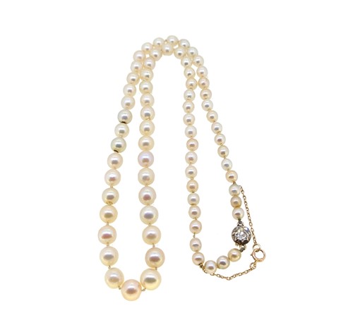 Lot 255 - A string of natural saltwater pearls with a diamond set clasp