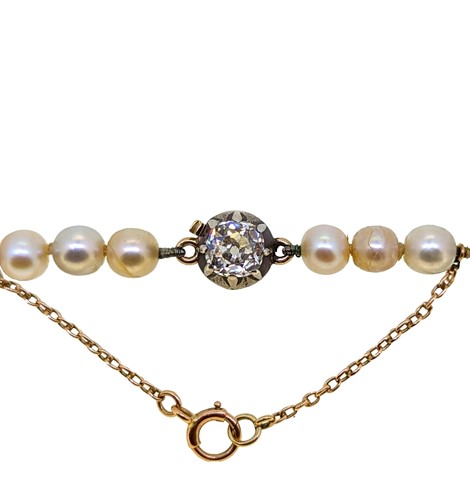 Lot 255 - A string of natural saltwater pearls with a diamond set clasp