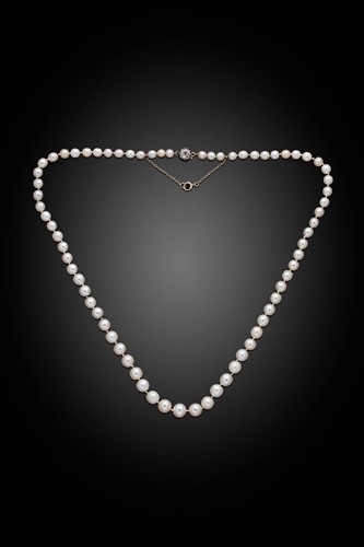 Lot 255 - A string of natural saltwater pearls with a diamond set clasp