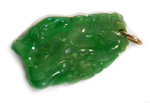 Lot 75 - A Chinese apple-green jade-type pendant, 20th century