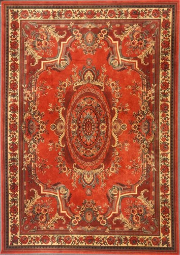Lot 510 - A machine woven red ground rug with repeating...