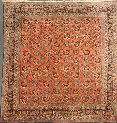 Lot 504 - A large red ground rug with repeating floral...