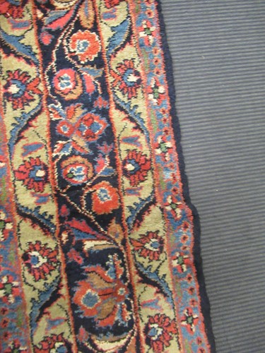 Lot 504 - A large red ground rug with repeating floral...