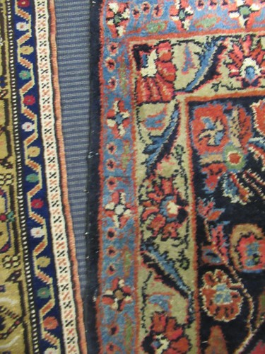 Lot 504 - A large red ground rug with repeating floral...