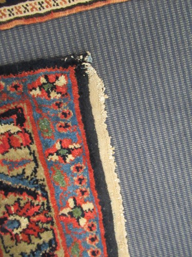Lot 504 - A large red ground rug with repeating floral...