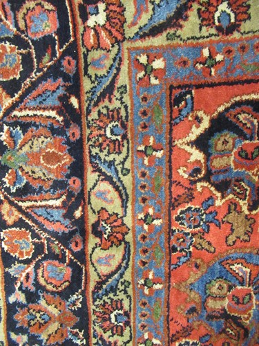 Lot 504 - A large red ground rug with repeating floral...