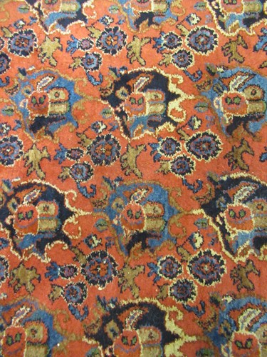 Lot 504 - A large red ground rug with repeating floral...