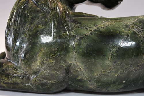 Lot 430 - A Chinese spinach jade type recumbent horse, Ming style