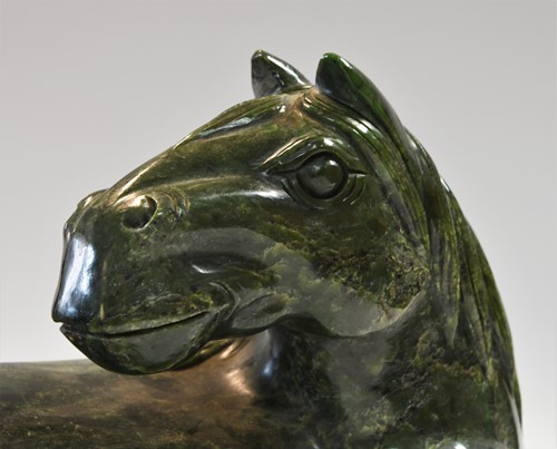 Lot 430 - A Chinese spinach jade type recumbent horse, Ming style