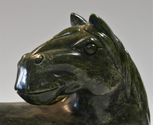 Lot 430 - A Chinese spinach jade type recumbent horse, Ming style