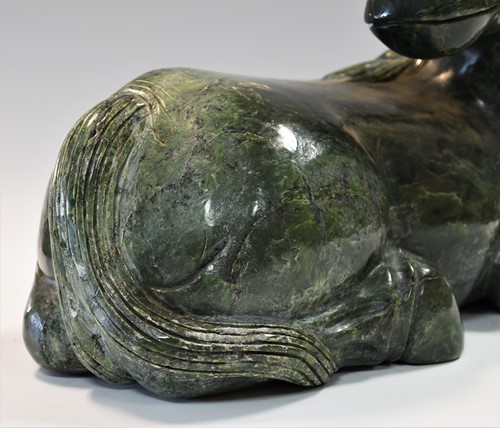 Lot 430 - A Chinese spinach jade type recumbent horse, Ming style