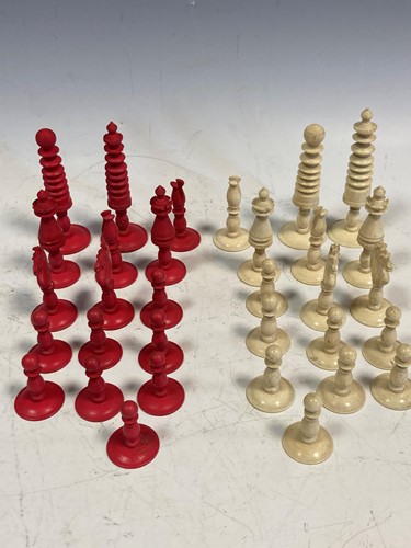 Lot 75 - A box of turned bone chess piece, one side...