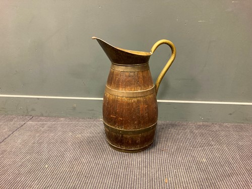 Lot 583 - An early 20th century brass bound oak jug with...