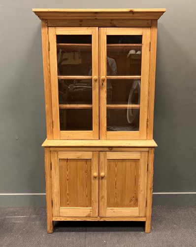 Lot 524 - An early 20th century pine glazed cabinet, the...