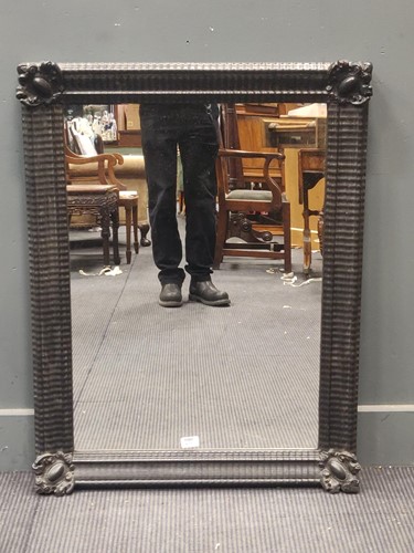 Lot 673 - A ebonsied rectangular wall mirror, the...