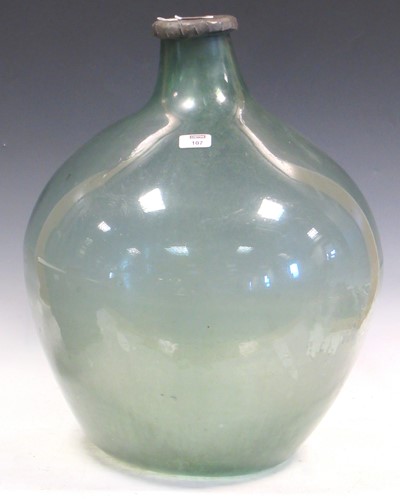 Lot 107 - An antique pale green glass carboy, the rim...
