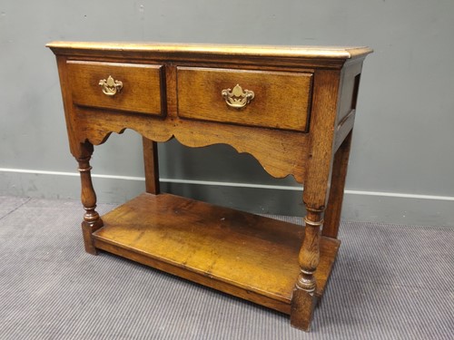 Lot 425 - A small oak dresser with a scalloped apron on...