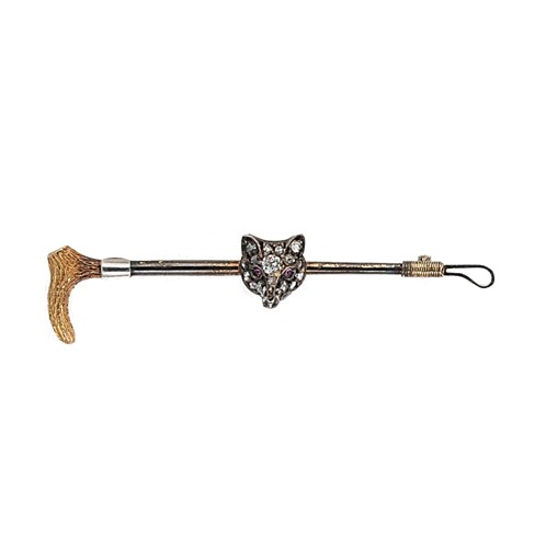 Lot 144 - A diamond and ruby set fox head and riding crop brooch