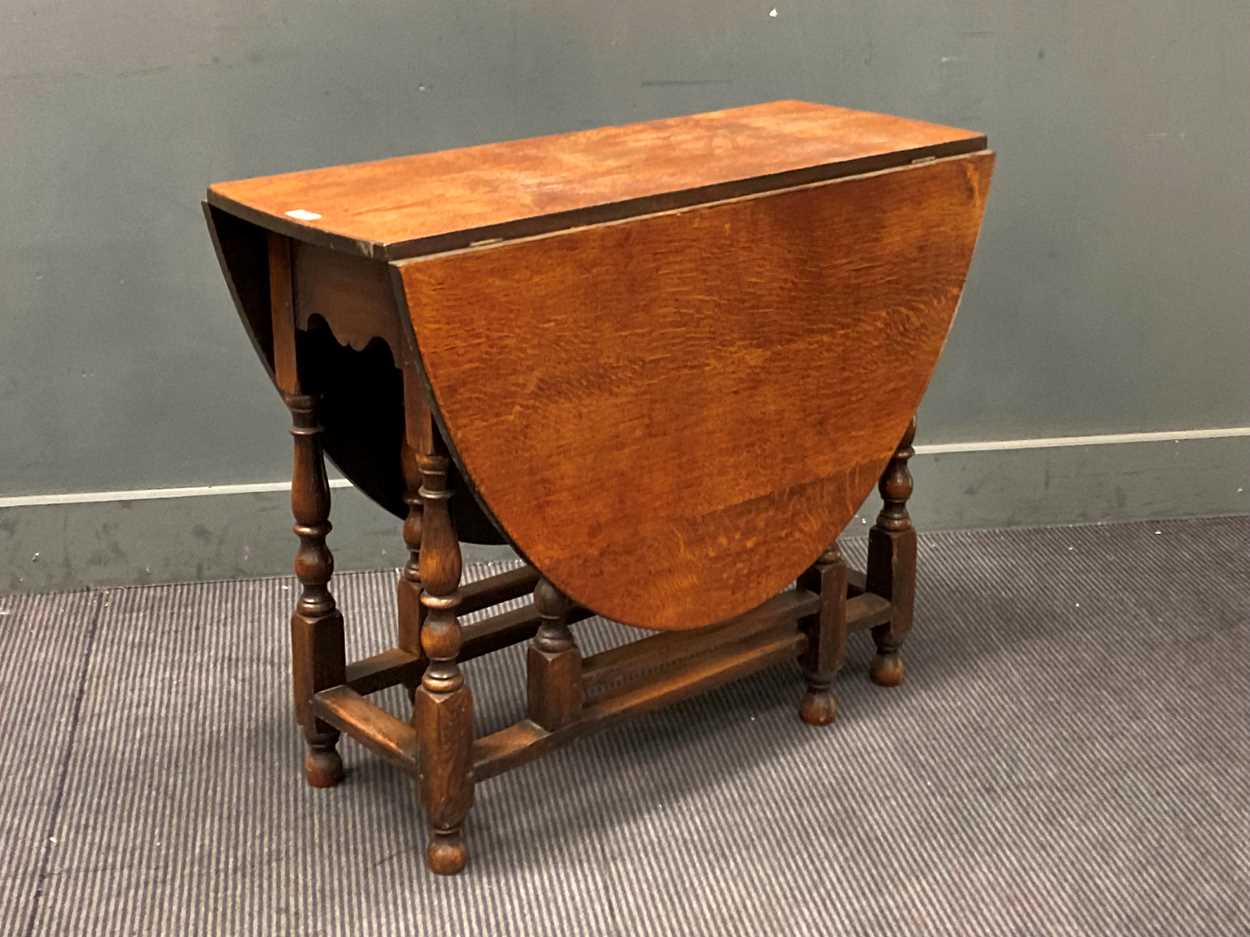 Lot 386 - An oak gateleg table with oval drop flap top,...