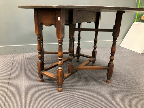 Lot 386 - An oak gateleg table with oval drop flap top,...