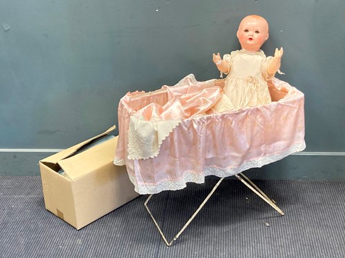 Lot 102 - A 1930s composition doll with spare clothing...