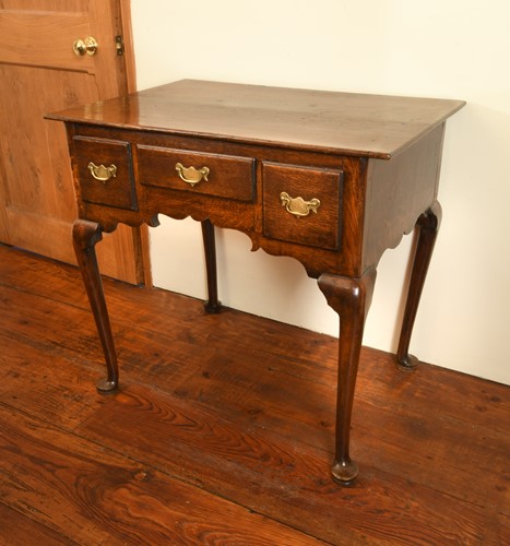 Lot 411 - A George III oak and fruitwood low boy