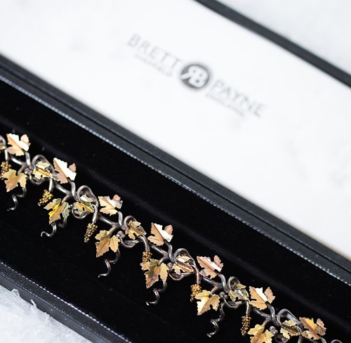 Lot 10 - Brett Payne - An 18ct gold and silver grape vine and corkscrew necklace