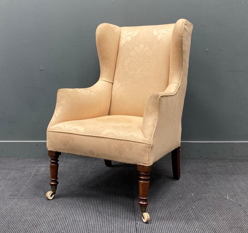 Lot 911 - A cream upholstered wingback armchair 108 x 70...