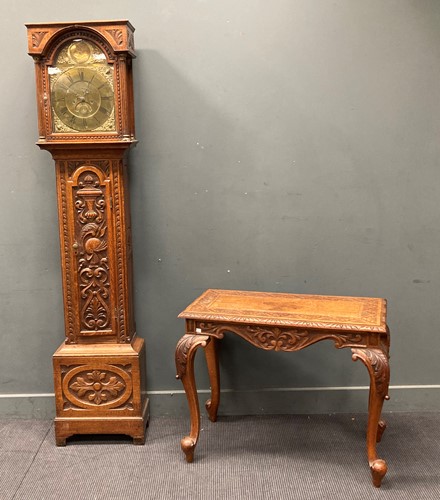 Lot 486 - An oak carved longcase clock, decorated with a...