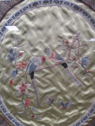 Lot 698 - An oval Chinese textile love birds, 39 x 34cm