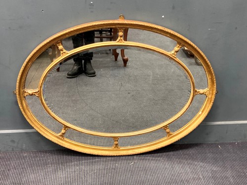 Lot 525 - A gilt oval hall mirror, the central plate...