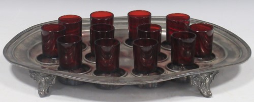 Lot 11 - A pewter shot holder tray with twelve red glasses