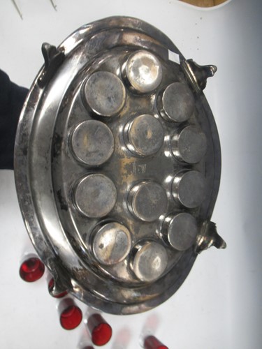 Lot 11 - A pewter shot holder tray with twelve red glasses
