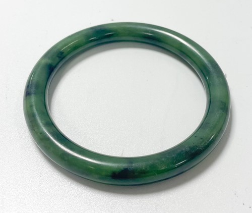 Lot 42 - A Chinese mottled green jade bangle