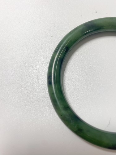Lot 42 - A Chinese mottled green jade bangle