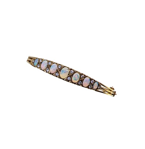 Lot 102 - A late 20th century 9ct gold opal and diamond hinged bangle