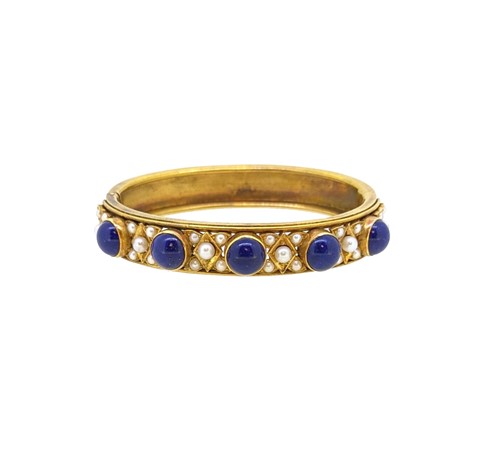 Lot 111 - A lapis lazuli and pearl set hinged bangle