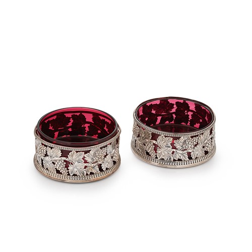 Lot 499 - A harlequin pair of George III silver bottle coasters