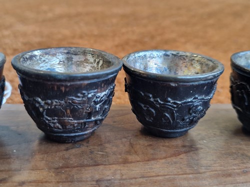 Lot 53 - A set of eight Chinese export carved and silver mounted coconut wood wine cups, Qing Dynasty, early 19th century